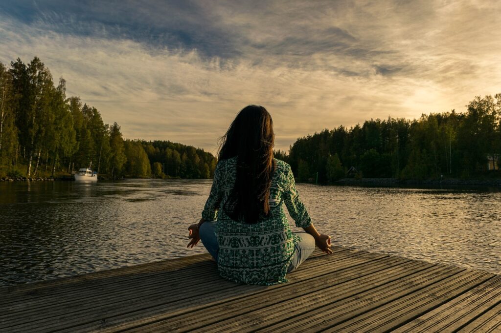 Frau meditiert am Fluss